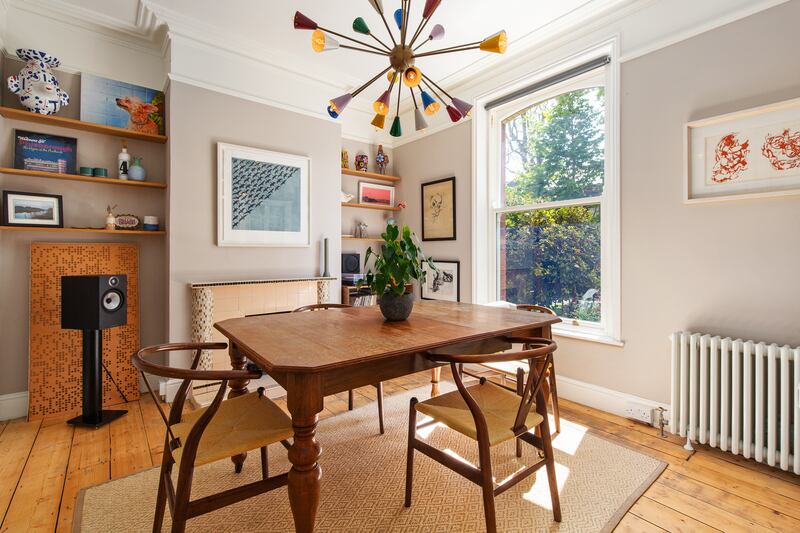 The first reception room looks out to the street through a sash window and features ceiling coving and a retro fireplace. Photograph: Keith Owens
