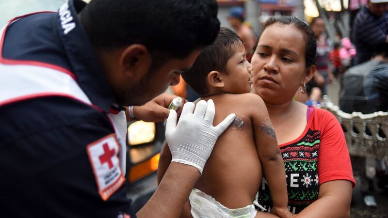 A paramedic attends a Honduran child migrant taking part in a caravan heading to the US, at the main square in Tapachula, Chiapas state, Mexico on Sunday. Photograph:  Johan Ordonez/AFP/Getty Images