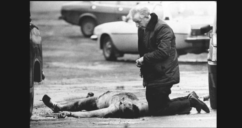 The scene in West Belfast in 1988 when two British soldiers were murdered after they drove into a Republican funeral. Fr Alec Reid is pictured giving one of the the soldiers the last rites. Photograph: Trevor McBride